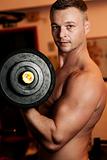 Man exercising his arm muscles by lifting two dumbell free weigh