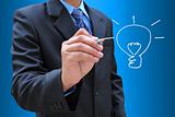 businessman hand drawing a light bulb