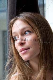 woman standing by a window looking outside