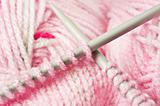 Knitting a pink baby jersey - yarn and pens