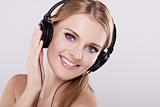 Portrait of happy young woman with headphones listening to music