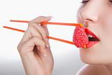 Girl with chopsticks and raspberry