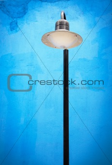Street lamp post against blue wall background