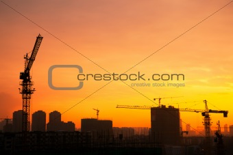 Silhouette of the tower crane on the construction site. 