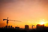 Silhouette of the tower crane on the construction site. 