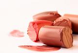 Multi-coloured scraps of lipstick on a white background for a make-up