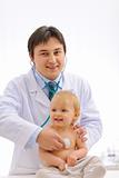 Smiling pediatric doctor checking baby using stethoscope