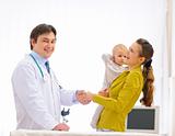 Mother thanking pediatrician doctor for baby examination