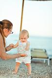 Baby playing with mother on beach