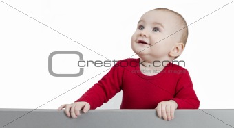 young child standing at grey cardboard