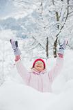 Happy girl having fun on snowing winter day.