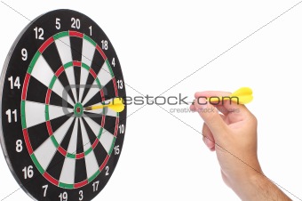 Hand throwing a yellow dart over white