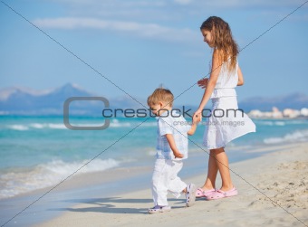Young girl and boy playing happily at pretty beach