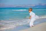Young cute boy playing happily at pretty beach