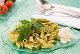 Pasta with pesto on green glass table