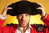 Bullfighter putting on big montera hat humor spanish colors 
