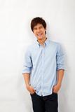 Happy smiling asian young man leaning against white wall