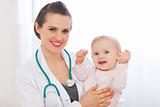 Portrait of pediatrician doctor with smiling baby
