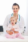 Portrait of pediatric doctor with baby looking on side