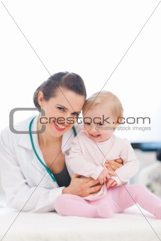 Portrait of laughing pediatrician doctor and baby