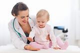 Cheerful baby high five to pediatrician doctor