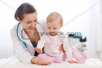 Cheerful baby high five to pediatrician doctor