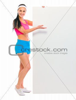 Fitness girl showing blank billboard