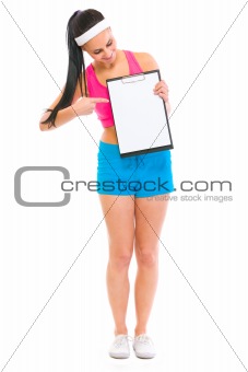 Fitness girl pointing on blank clipboard