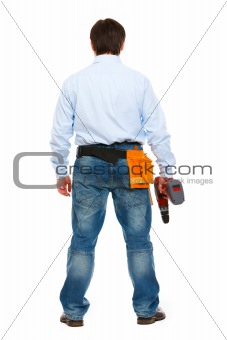 Full length portrait of construction worker standing back to camera