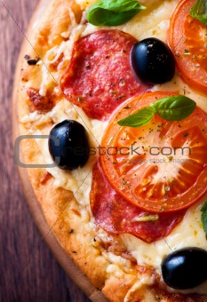 Pizza with salami, tomatoes and olives