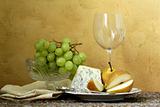 still life glass of wine, blue cheese, green grapes and pears on the table, vintage