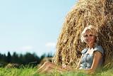 girl next to a stack of hay