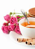 tea in cup with biscuits and bouquet roses