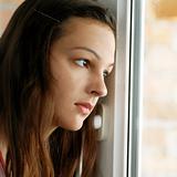 Teenage girl looking out  window
