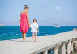 Girl with her brother walking on jetty