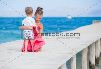 Girl with her brother walking on jetty