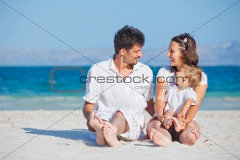Family sitting on tropical beach