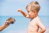 Young boy plaing with crab