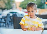 portrait of adorable little boy drinking juice