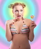 surprised blond girl playing with candy