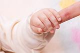 Close-up of baby's hand holding mother's finger