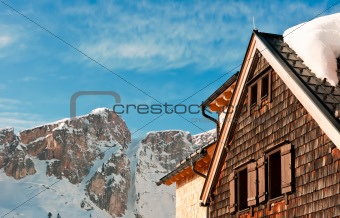 Alpine hut in front of a mountain peak in winter