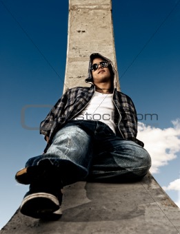 Young man urban fashion portrait over sky background