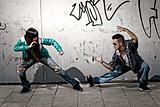 Young urban couple dancers hip hop dancing fight acting urban scene