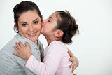 Daughter kissing her mum