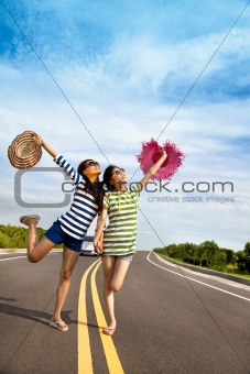 two girls having fun on the road trip at summertime