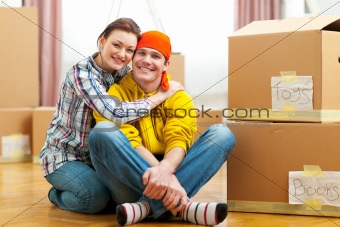 Portrait of moving to new house young couple among boxes