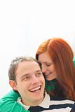 Red hair young woman whispering in boyfriends ear
