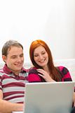 Happy young couple having fun time with laptop