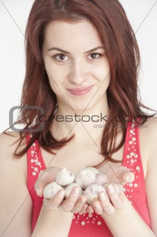 Young woman holding garlic in her hands